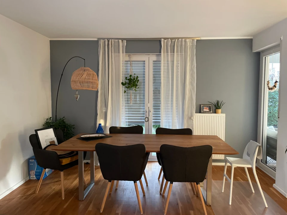 Original dining area with a wooden table, chairs, window and radiator